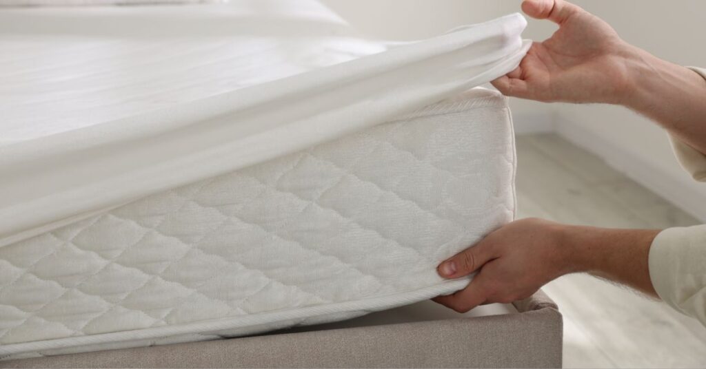 Nakładanie prześcieradła na materac przeciwodleżynowy przygotowany do opieki nad pacjentem leżącym